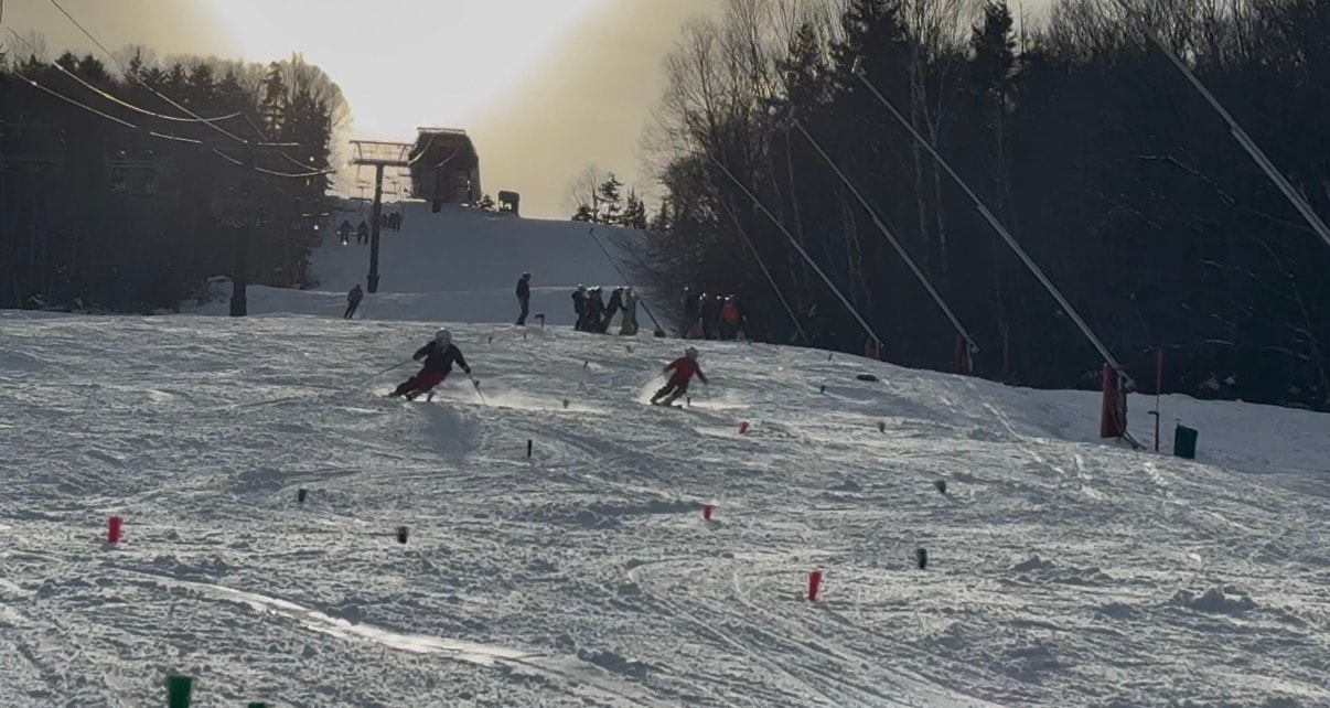 Coach observing athlete on mountain slope